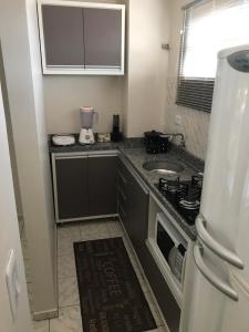 a small kitchen with a sink and a stove at Apartamento foz centro 03 in Foz do Iguaçu