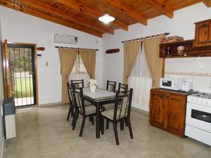 uma sala de jantar com uma mesa e cadeiras numa cozinha em Cabañas Mirmar Mendoza em Mendoza