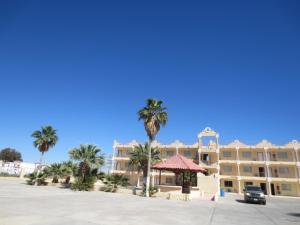 a large building with palm trees in front of it at Hotel Plaza Peñasco in Puerto Peñasco
