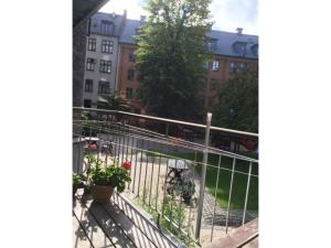 a balcony with a fence and some plants and buildings at ApartmentInCopenhagen Apartment 655 in Copenhagen