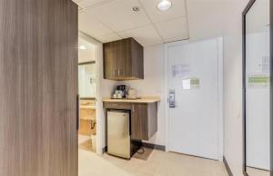 a kitchen with wooden cabinets and a refrigerator at Aqua Palms Waikiki #304 and #1112 in Honolulu