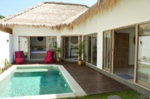 une villa avec une piscine et une maison dans l'établissement Villa Kayu, à Gili Air