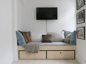 a couch with pillows and a television on a wall at ApartmentInCopenhagen Apartment 1267 in Copenhagen