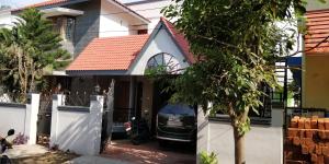 ZuriEL Suite GUEST HOUSE في كويمباتور: منزل به دراجة نارية متوقفة في الممر