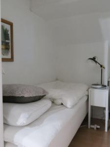 コペンハーゲンにあるApartmentInCopenhagen Apartment 1316の白い枕とランプ付きの白いベッド