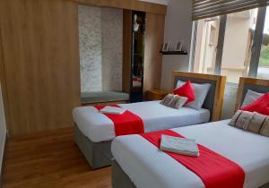 a hotel room with two beds with red and white sheets at Seri Bayu Resort Hotel in Kampong Bagan Lalang
