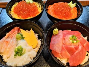 four bowls filled with different types of food on a stove at Dormy Inn Sapporo Annex in Sapporo
