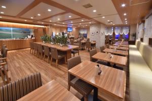 a restaurant with wooden tables and chairs at Dormy Inn Sapporo Annex in Sapporo