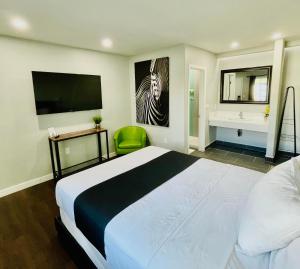 a bedroom with a large bed and a television at Villa Serena in El Cajon