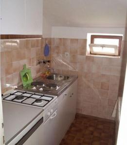 eine kleine Küche mit Herd und Spüle in der Unterkunft Apartments Drago - apartments in the center in Biograd na Moru