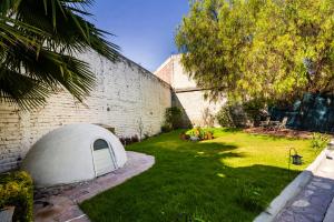 a white tent in a yard next to a brick wall at Hotel Plaza Galindo in San Juan de los Lagos
