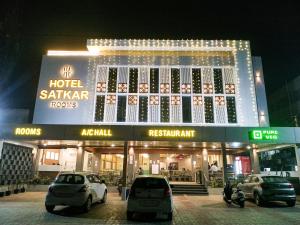 ein Gebäude mit nachts vor ihm geparkt in der Unterkunft HOTEL SATKAR CHHATRAL in Kalol