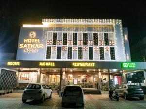 KalolHOTEL SATKAR CHHATRAL的一座建筑,晚上停在前面