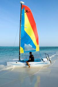 a man sitting on a sail boat on the beach at The Palms Zanzibar in Bwejuu