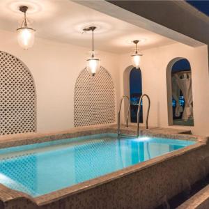 a large swimming pool in a room with at Villa 243 in Jaipur