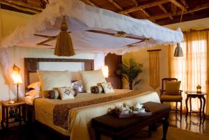 a bedroom with a large bed with a canopy at The Palms Zanzibar in Bwejuu