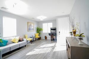a living room with a white couch and yellow chairs at 2400SqFt House 6beds 3bath Pool table BBQ in Las Vegas