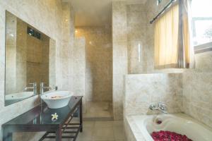 a bathroom with a tub and a sink and a bath tub at Iman Homestay Ubud in Ubud