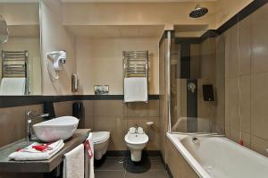 a bathroom with a toilet a sink and a bathtub at Hotel Caravel in Rome