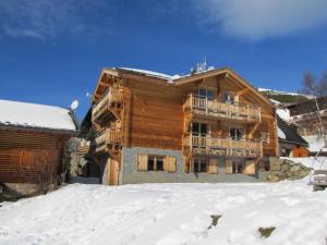 a log house in the snow with a balcony at Chalet La Breche in LʼHuez