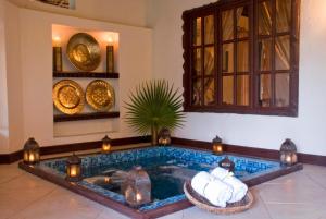 a swimming pool in a room with lights and candles at The Palms Zanzibar in Bwejuu