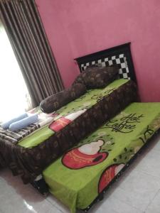 dwa łóżka siedzące obok siebie w pokoju w obiekcie Rumah Puan Homestay w mieście Bandar Lampung