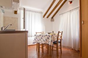 a kitchen with a table and chairs in a kitchen at Apartments Donika in Komiža