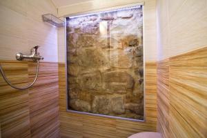 y baño con ducha de piedra y pared de piedra. en Apartments Donika, en Komiža