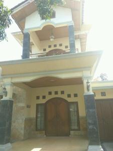 una casa con una puerta grande y un garaje en Rumah Puan Homestay, en Bandar Lampung