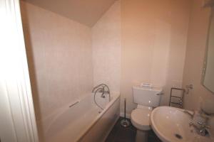 a bathroom with a tub and a toilet and a sink at 2 Clifden Court in Clifden