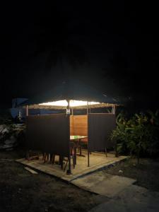 - une table de pique-nique avec un parasol noir la nuit dans l'établissement Kadampil Bliss, à Maraiyūr