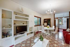 ein Wohnzimmer mit einem roten Sofa und einem TV in der Unterkunft Villa Louise Sorrento in Sorrent