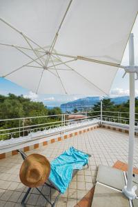 eine Terrasse mit einem Stuhl und einem Sonnenschirm in der Unterkunft Villa Louise Sorrento in Sorrent