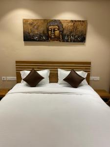 Verāval的住宿－HOTEL DAMODAR，卧室配有一张白色大床和床头板