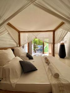 1 cama grande con sábanas y almohadas blancas en Samura Maldives Guest House Thulusdhoo en Thulusdhoo