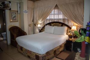 a bedroom with a large bed and a window at Lenasia Guest Lodge in Lenasia