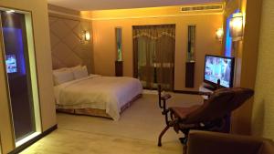 高雄市にあるI Travel Motelのベッドとテレビが備わるホテルルームです。