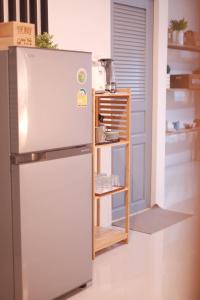 um frigorífico numa cozinha ao lado de uma porta em Ma-TaÔ またお Café & hostel em Nan