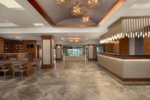 eine Lobby mit einer Bar, Tischen und Kronleuchtern in der Unterkunft La Quinta by Wyndham Giresun in Giresun