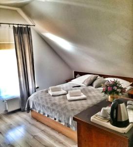 a bedroom with a bed with two towels on it at Apartamenty Pod Lwem in Świdnica