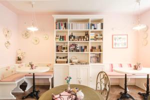 una habitación con 2 mesas y un estante con libros en B&B Casa Dolce Casa en Oltre il Colle