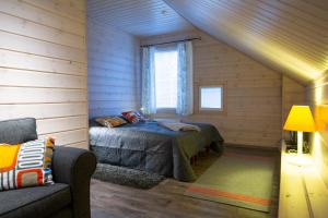 een slaapkamer met een bed en een bank in een kamer bij Ettomies II in Äkäslompolo