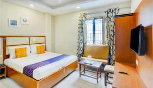 Cette chambre comprend un lit et une télévision. dans l'établissement SAROVAR INN, à Chennai