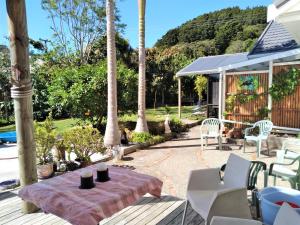 een patio met een tafel en stoelen en een huis bij U Beauty - B & B in Whangarei