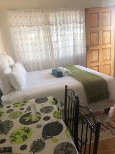 a bedroom with a bed with a green and white blanket at Yonz Self Catering Units in Port Alfred
