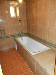 a bath tub in a tiled bathroom with a window at La Petite Gorge, Hôtel & Restaurant Todra Gorge in Tinerhir
