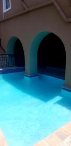 a swimming pool with blue water in a building at African Sun lodge in Durban