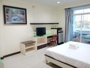 1 dormitorio con 1 cama y escritorio con TV en โรงแรมไดมอนด์แกรนด์ เฮ้าส์ แอนด์ รีสอร์ท en Chiang Mai
