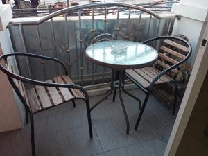 a glass table and a bench on a balcony at โรงแรมไดมอนด์แกรนด์ เฮ้าส์ แอนด์ รีสอร์ท in Chiang Mai
