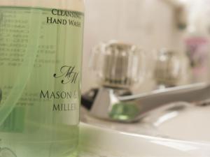 a bottle of hand wash sitting on a bathroom sink at Moss Cottage in Stratford-upon-Avon